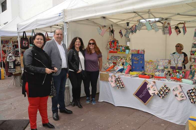 Autoridades y la pregonera, junto a un puesto de la feria de artesanía (Foto TA)